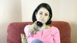 Woman is watching tv and changing tv-channels