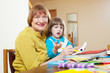 grandmother and child drawing with  pencils