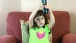 Little girl trying to change channels on tv with remote control