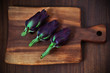 Artichokes, three, small, violet on a cutting board