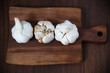 Foto: Three big garlic bulbs full with garlic cloves on cutting board Three big garlic bulbs full with garlic cloves on cutting board