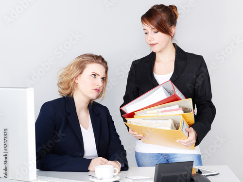Photo: Two female office assistants have to much work Two female office assistants have to much work