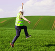 Engeeneer jumping for joy on green field