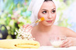 Beautiful young woman with cream for face mask towel