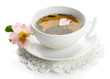 Cup of herbal tea with hip rose flowers, isolated on white