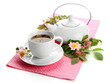 Cup and teapot of herbal tea with hip rose flowers, isolated