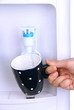 Woman filling cup at water cooler