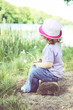 girl sitting on the bank of the river