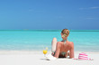 Girl with a glass of orange juice on the beach of Exuma, Bahamas