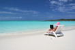 Girl with a laptop on the tropical beach. Exuma, Bahamas