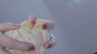 Hands of young woman tear orange apart.