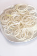 Onion rings on white plate on white background