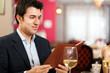 Foto: Man reading a menu in an elegant restaurant Man reading a menu in an elegant restaurant