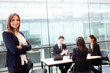 Beautiful businesswoman smiling with his colleagues behind