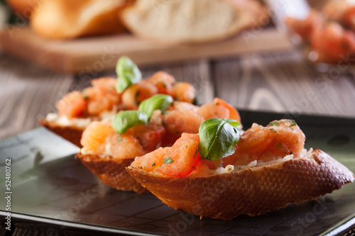 Photo: Bruschetta with mozzarella and tomato. Selective focus Bruschetta with mozzarella and tomato. Selective focus