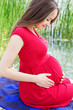 Photo: Young attractive pregnant woman enjoying near lake Young attractive pregnant woman enjoying near lake