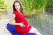 Photo: Young attractive pregnant woman enjoying near lake Young attractive pregnant woman enjoying near lake