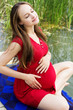 Photo: Young attractive pregnant woman enjoying near lake Young attractive pregnant woman enjoying near lake