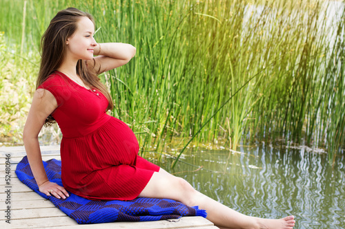 Photo: Young attractive pregnant woman enjoying near lake Young attractive pregnant woman enjoying near lake
