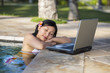 Enjoying holiday with laptop in the pool