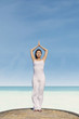 Pretty woman doing yoga on the beach