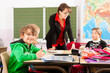 Foto: Schulkinder und Lehrerin lernen an der Schule Schulkinder und Lehrerin lernen an der Schule