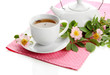 Cup and teapot of herbal tea with hip rose flowers, isolated