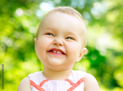 Photo: Little Baby Girl Portrait outdoor. Child over nature background Little Baby Girl Portrait outdoor. Child over nature background