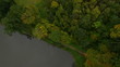 Aerial flight over trees and rural pond in autumn