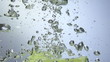 Fresh lime dropped into water with splash