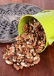 Overturned bucket with nuts on wooden background