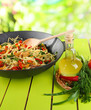 Noodles with vegetables on wok on nature background background