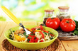 Noodles with vegetables on wok on nature background