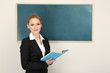 Photo: Portrait of teacher woman near chalkboard in classroom Portrait of teacher woman near chalkboard in classroom