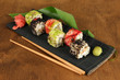 Tasty Maki sushi - Roll on mat on brown background
