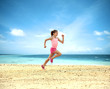 Little girl running along the ocean