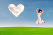 Asian girl jumping on green field