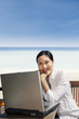 Asian entrepreneur working with laptop at beach