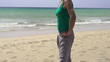 Happy woman standing on the beach, super slow motion