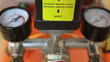 In and out pressure gauges of air compressor and caution sign