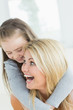 Laughing mother giving daughter a piggy back