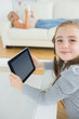 Smiling girl using tablet computer while mother is reading
