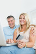 Husband and wife shopping online with laptop