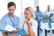 Photo: Young doctors talking about a blue file Young doctors talking about a blue file