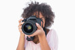 Woman with afro wearing pink top taking a photo