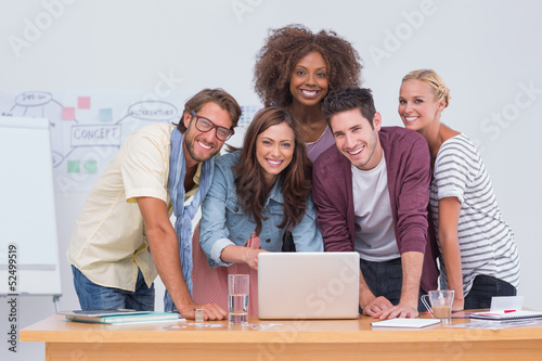 Photo: Creative team standing at desk with laptop Creative team standing at desk with laptop