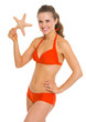 Portrait of smiling young woman in swimsuit starfish