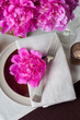 table setting with pink peonies, vintage cutlery and brown table