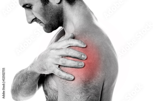 Photo: Closeup of young man having pain in shoulder Closeup of young man having pain in shoulder