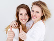 Two girls are happy at her friendship, showing thumbs up